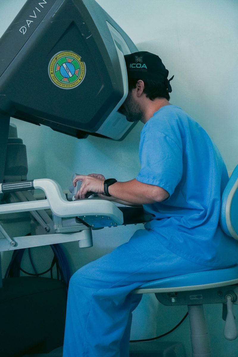 Dr. Mateus Colturato no console da plataforma robótica Da Vinci, em São José do Rio Preto